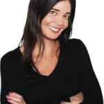 Silvia Leal sonriendo con brazos cruzados en una camiseta negra