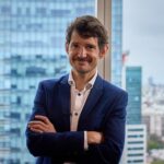 Retrato de un hombre sonriente en un entorno urbano moderno