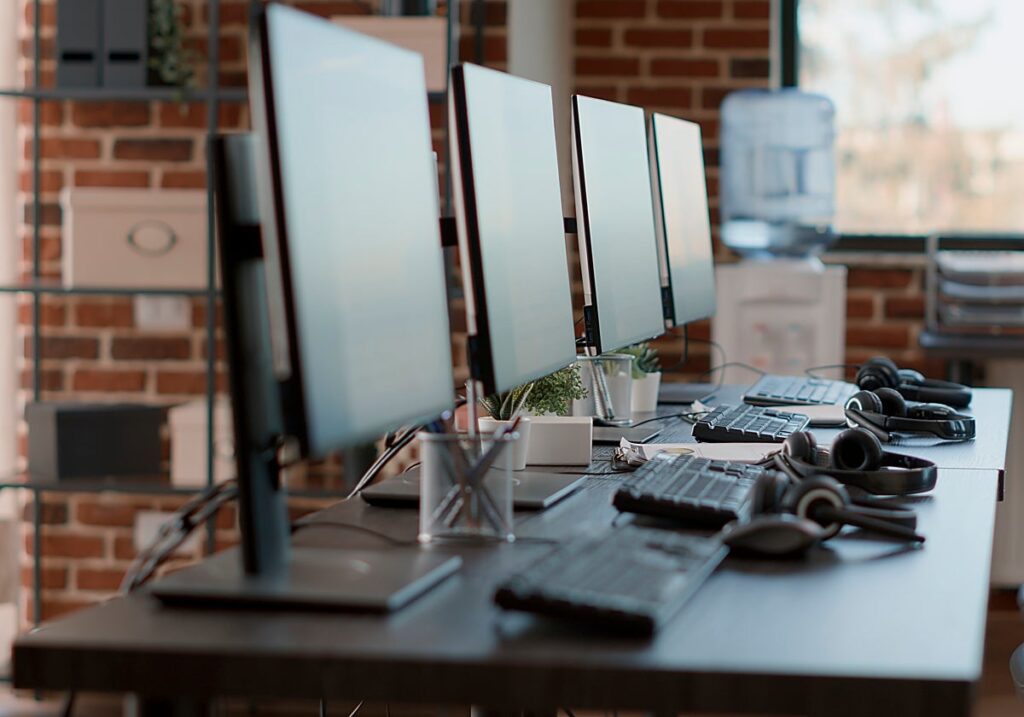 Escritorio con varios monitores y teclados en un entorno de trabajo