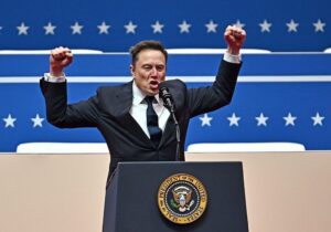 Elon Musk levanta los puños detrás de un podio con el sello presidencial estadounidense.