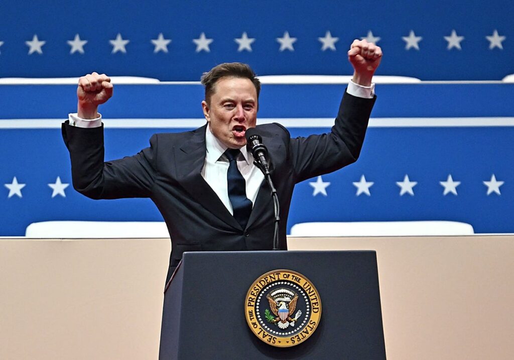 Elon Musk levanta los puños detrás de un podio con el sello presidencial estadounidense.