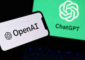 Pantallas con los logotipos de OpenAI y ChatGPT sobre un teclado iluminado.